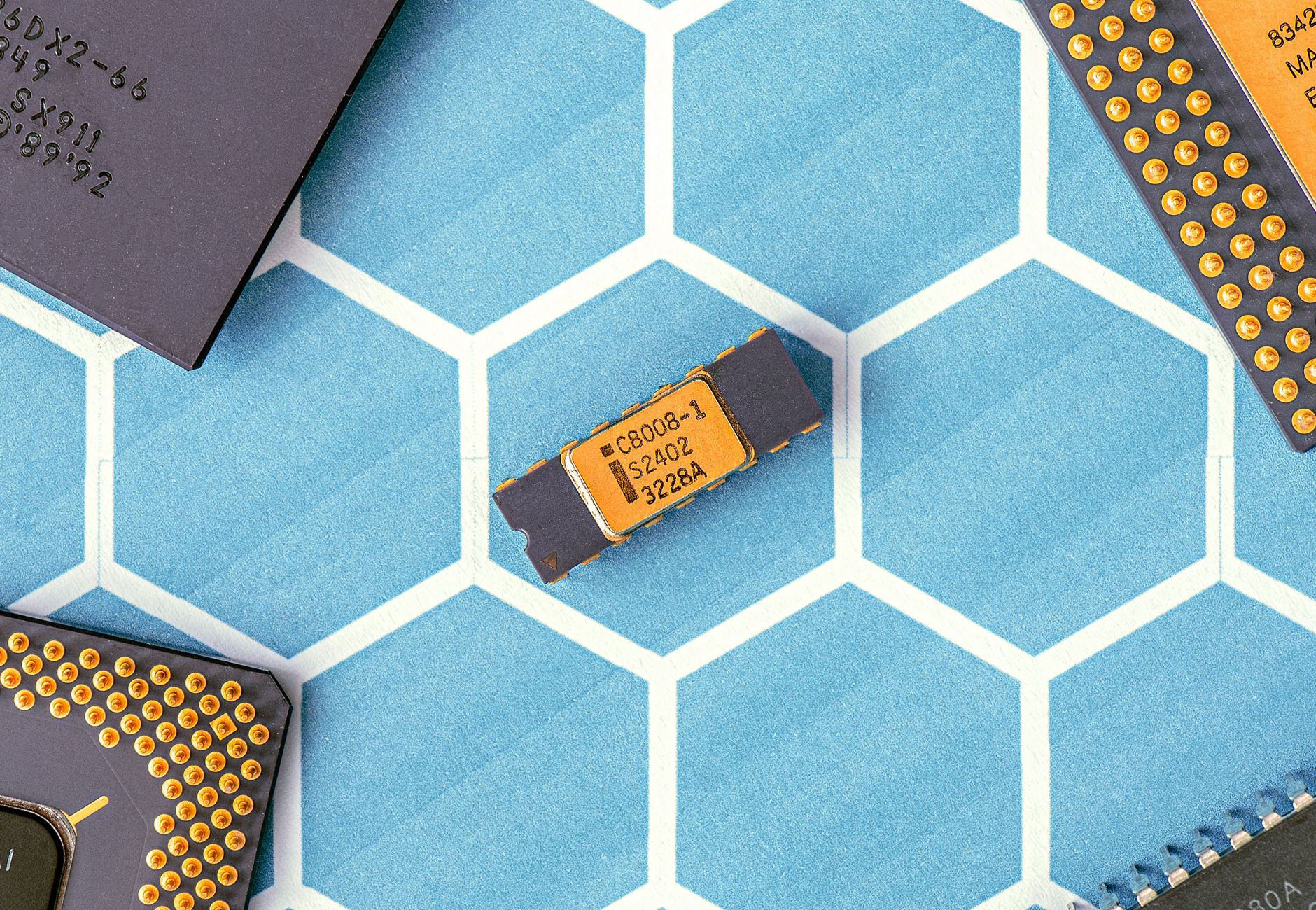 Close-up of various microprocessor chips on a blue hexagonal patterned surface, highlighting electronic technology.